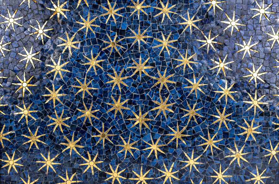 A mosaic of golden stars on a rich blue background, creating a celestial pattern that evokes the night sky.