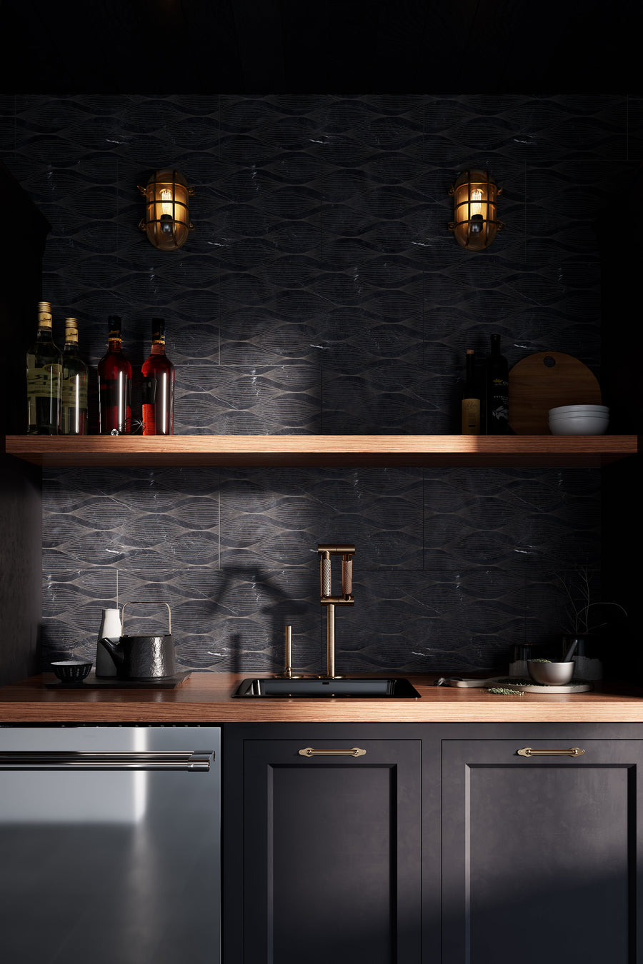 Modern kitchen with dark cabinetry, wooden countertop, shelf, and industrial-style lights. The wall features a black tile etched with a white, organic pattern.