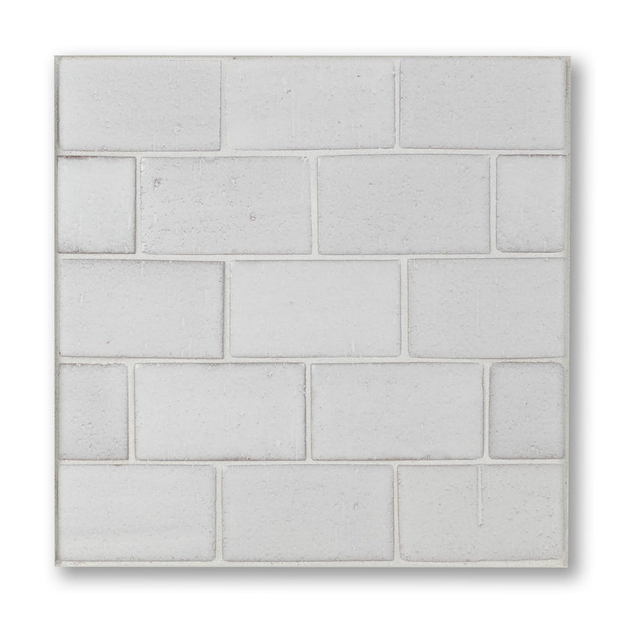 Rectangular concrete paver with a grid pattern on a white background
